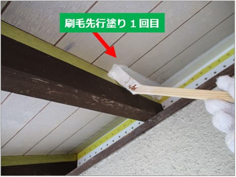 戸建て住宅の軒天を刷毛で塗装している状況