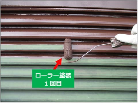 戸建て住宅の雨戸にローラーで中塗り塗料を塗装している状況