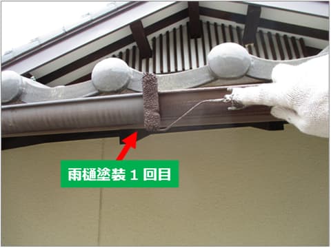 戸建て住宅の雨樋に中塗り塗料を塗装している状況