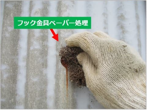 外壁フック金具の錆びをペーパーで落としている状況