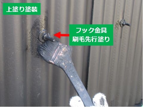 スレート外壁のフック金具の上塗りを刷毛で塗装している状況