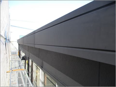 外装塗装塗り替え工事後の大型倉庫付き店舗のパラペットの状況