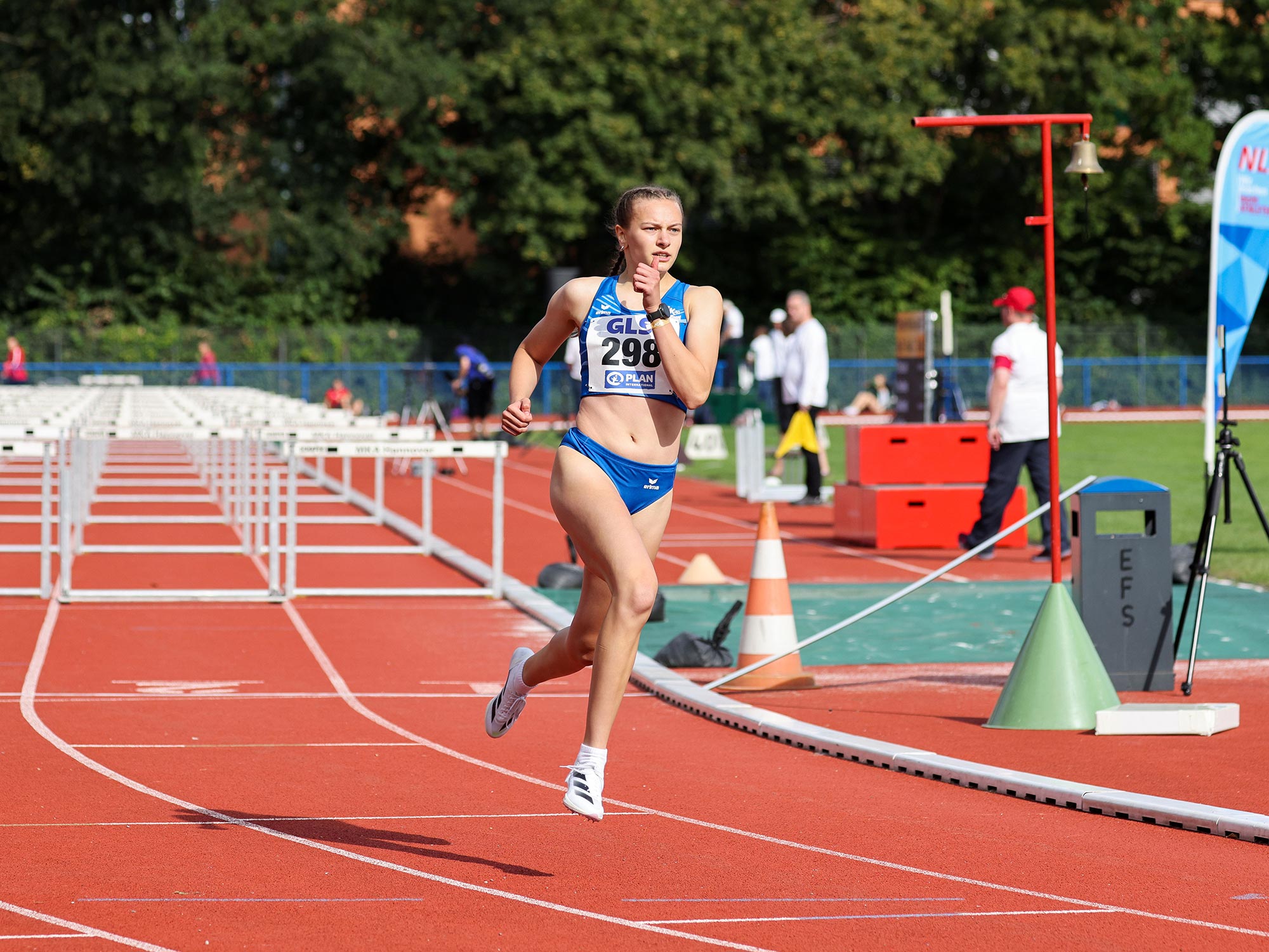 Leichtathletik-Stadion mit Läufern auf der Tartanbahn beim Training.